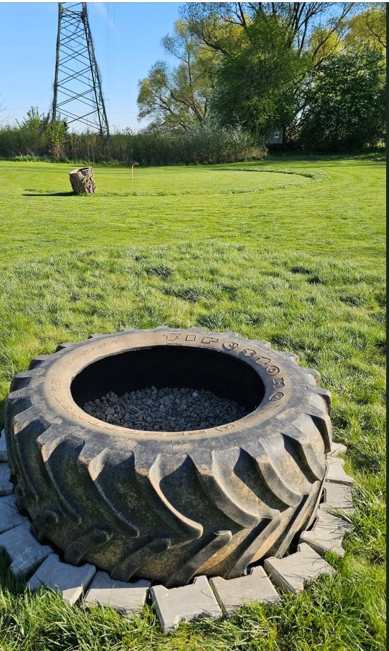 Pneumatika traktoru jako překážka na hřišti, v pozadí elektrický stožár
